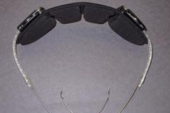 Orthodontic protective eyewear with dark lenses and clear frames, viewed from above.