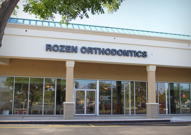 Rozen Orthodontics storefront exterior with glass windows and signage on a sunny day.