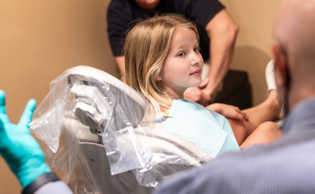 Young child receiving orthodontic examination or treatment in dental office setting.