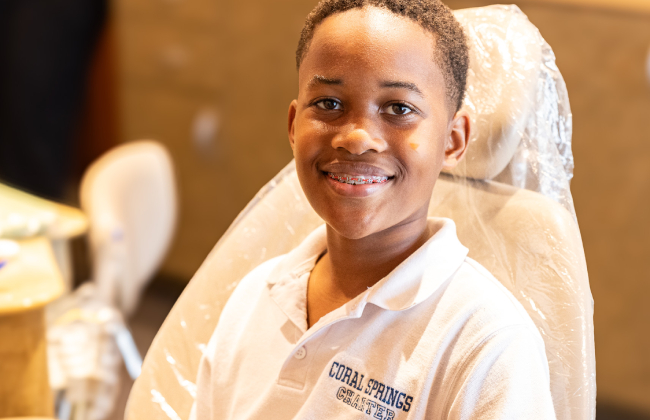Smiling orthodontics professional in white coat at dental practice office