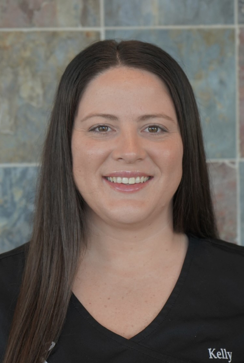 Professional headshot of Kelly, orthodontics staff member, smiling at camera in office setting.